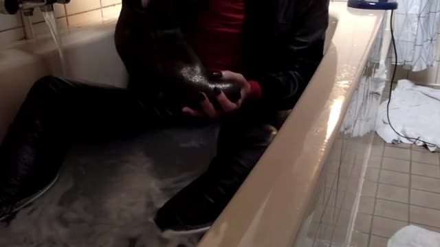 Bath wetlook in leather boots, leather jacket, tight pants and a red dress
