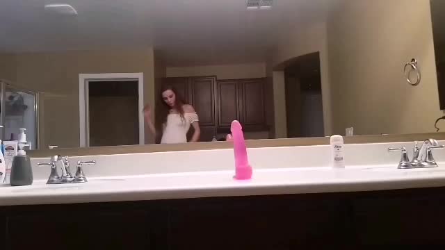 Riding a pink suction dildo in the bathroom