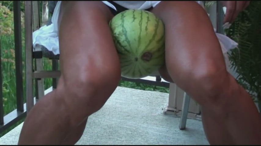 Latia Del Riviero using her muscular thighs to crush a watermelon.
