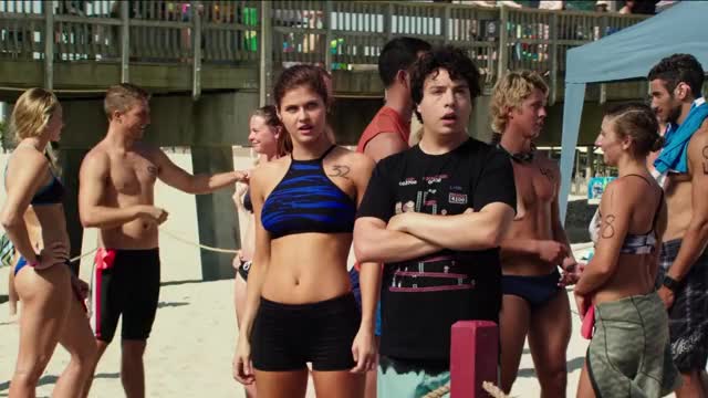 Alexandra Daddario - Baywatch - standing in blue two-piece swimsuit, watching another