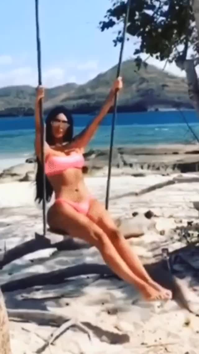 Kim Kardashian swinging with a pink bikini