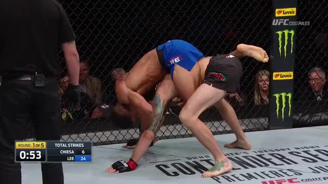 Kevin Lee bites his glove to set up the rear naked choke