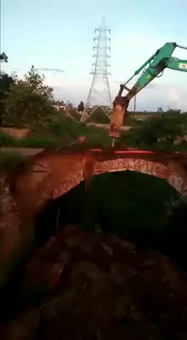 crane tries to demolish an old bridge for construction