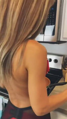 Rachel in red undies and big bow cooking bacon 🥓