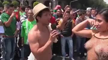 Mexican tv host gets a busty girl to get completely naked in a very busy square (sauce