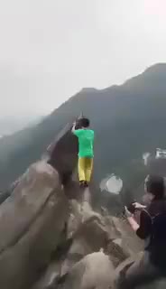 A Chinese man falls off a cliff when climbing down a rock after photoshooting