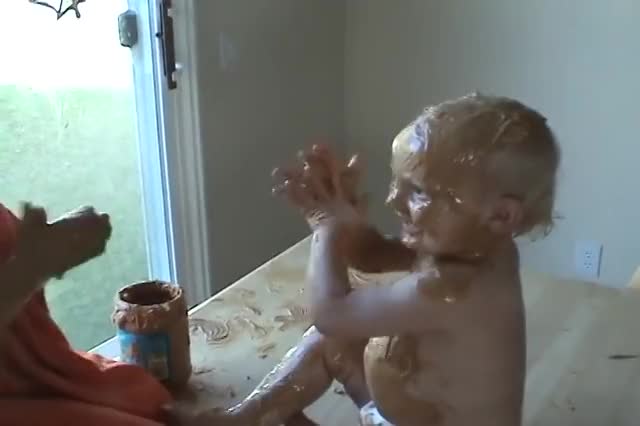 Sister Covers Baby Brother in Peanut Butter