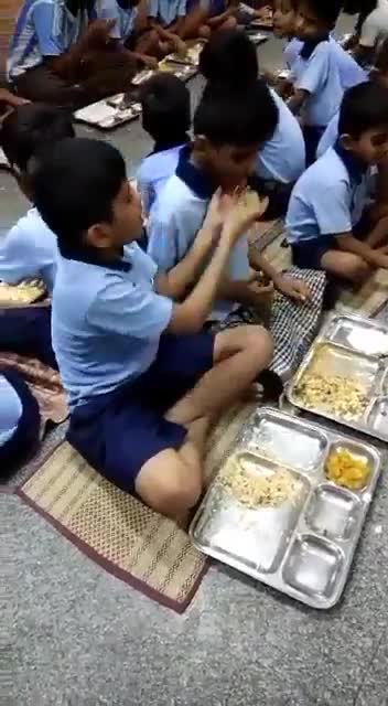 Kind boy feeding his mentally challenged friend