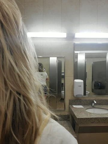 Showing off my butt plug in a public restroom.