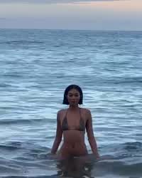 Beautiful woman walking in from the sea shore: Edwina Carla Isaacs in skimpy bikini