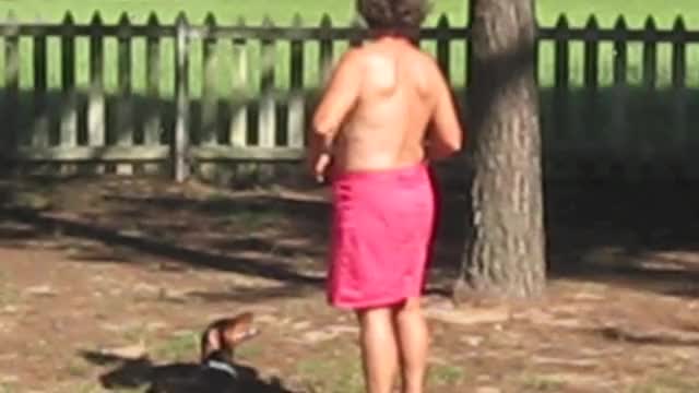 Back view of topless woman in yard
