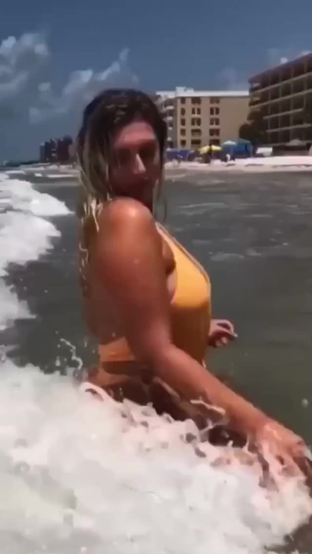 Sexy Sophie Eloise showing off her orange swimwear in the waves