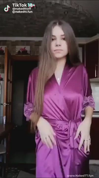 Brunette removes pink silk robes.