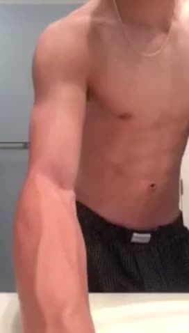 Sexy boy flexing in front of the mirror