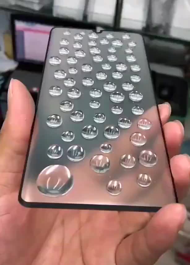 Water droplets slithering on the screen of a smartphone