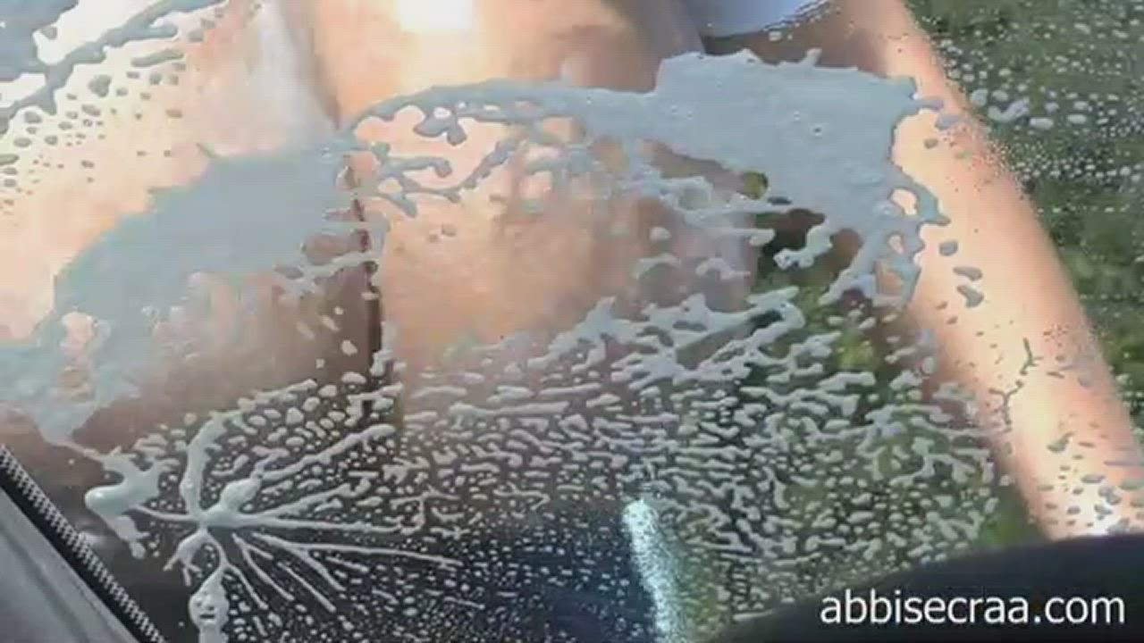 Abbi washing her car window with her wet soapy tits