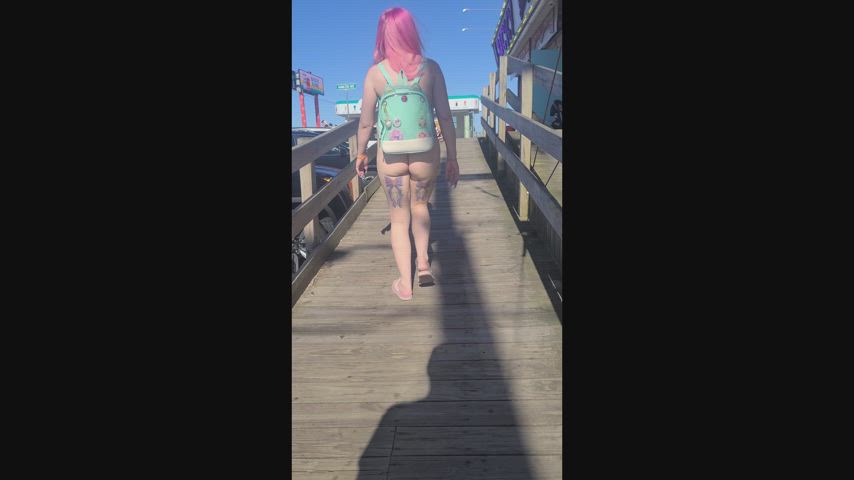 Wearing a micro bikini on the boardwalk looking naked from behind