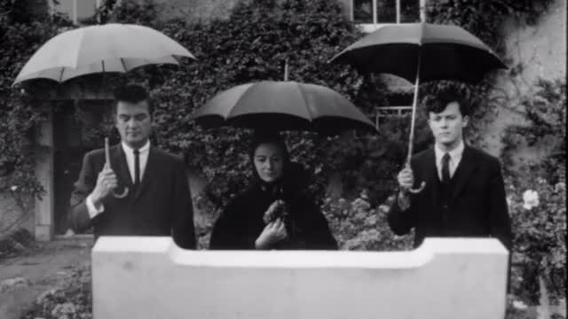 Dementia-13-1963-00-23-21-umbrellas-at-grave