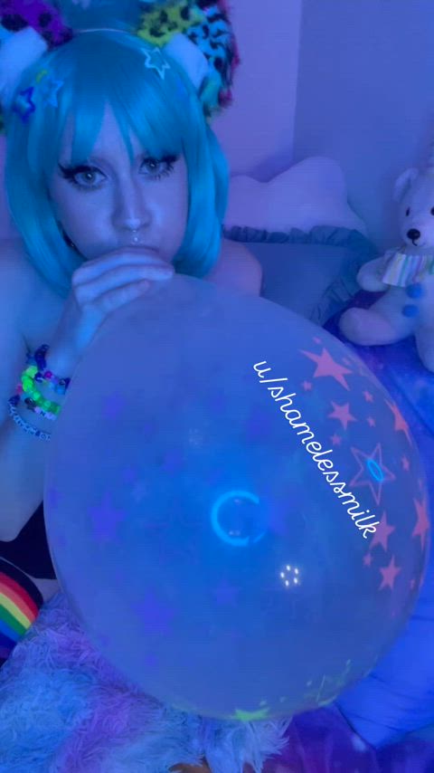 Blowing a big balloon under black light 