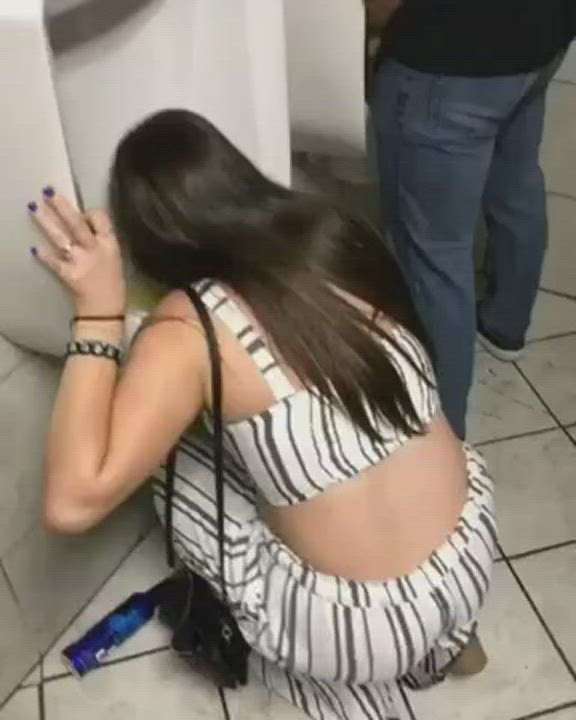 I just don't understand what's going on in here. Is she licking the urinal?