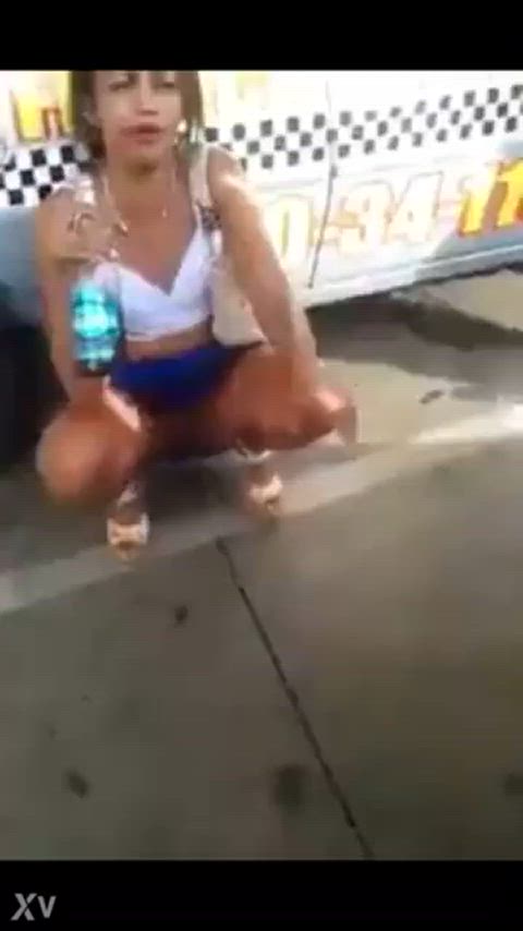 Girl pissing on the side of the street