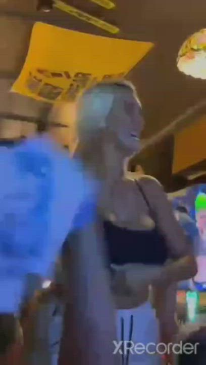show boobs in a bar with many men