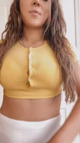 This spunky brunette thinks her yellow crop top looks best with the snaps unbuttoned