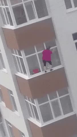 Woman cleaning the outside of her apartment window