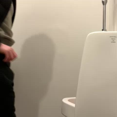 Asian guy pissing at urinal