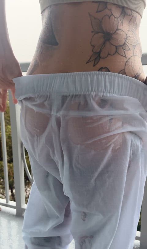 Stripping wet white pants in the rain revealing my green thong and tag.