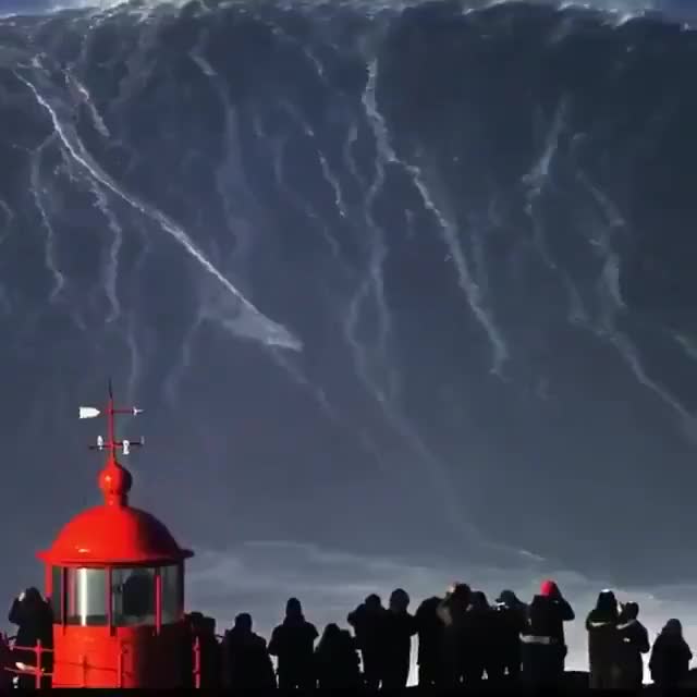 A brave surfer riding on a wave that is measured around 82 feet high