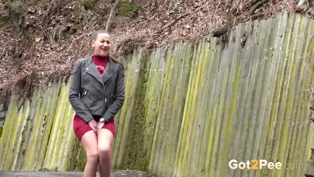 Cute brunette rushing to spray a stream of piss against a wall - Watch the full video