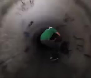 Chris Cope skateboarding through a tunnel
